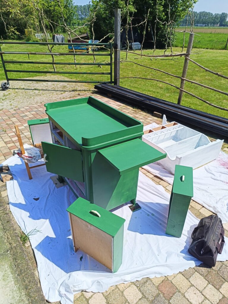 De groene jaren 50 commode die van vergeeld wit naar een frisse groene kleur wordt geverfd. Retro nieuw.